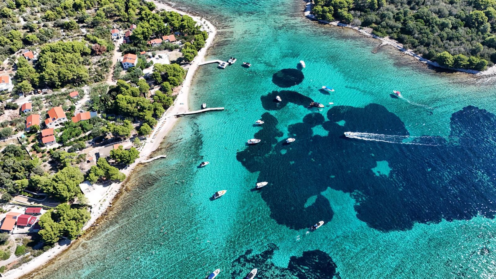 Boats anchored in the turquoise water of the Blue Lagoon near Krknjaši